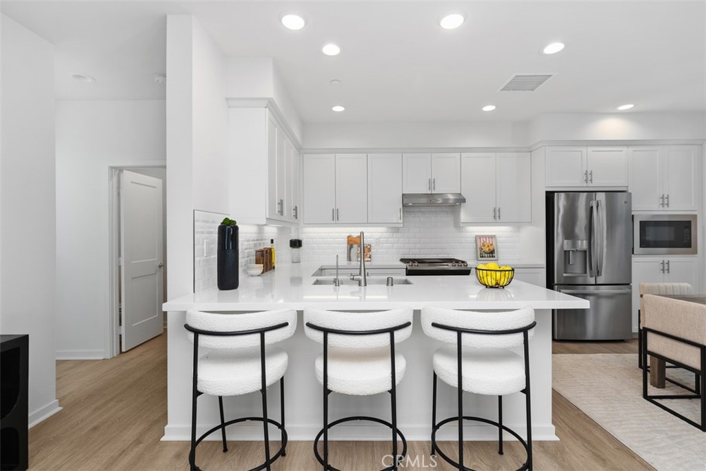 155 Fable Irvine, CA 92618 - Photo 9 of 41 a kitchen with stainless steel appliances a dining table chairs refrigerator and microwave