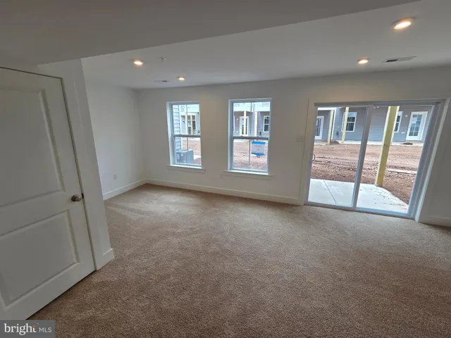 an empty room with a fireplace and large window