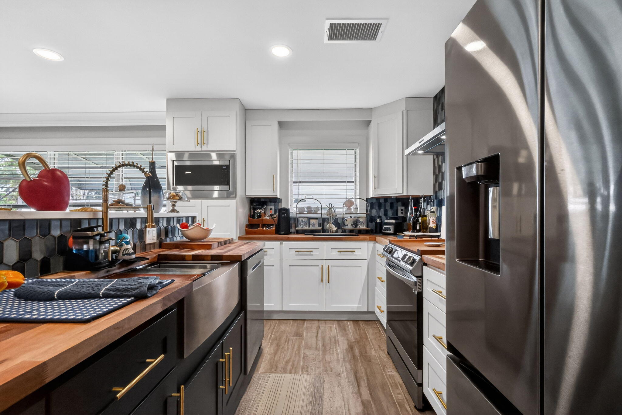 212 West High Point Terrace, Unit C Delray Beach, FL 33445 - Photo 16 of 35 a kitchen with stainless steel appliances granite countertop a refrigerator a stove and white cabinets