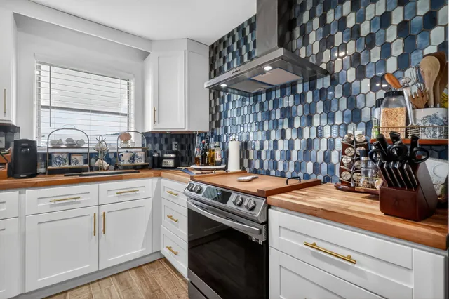 a kitchen with a stove and white cabinets