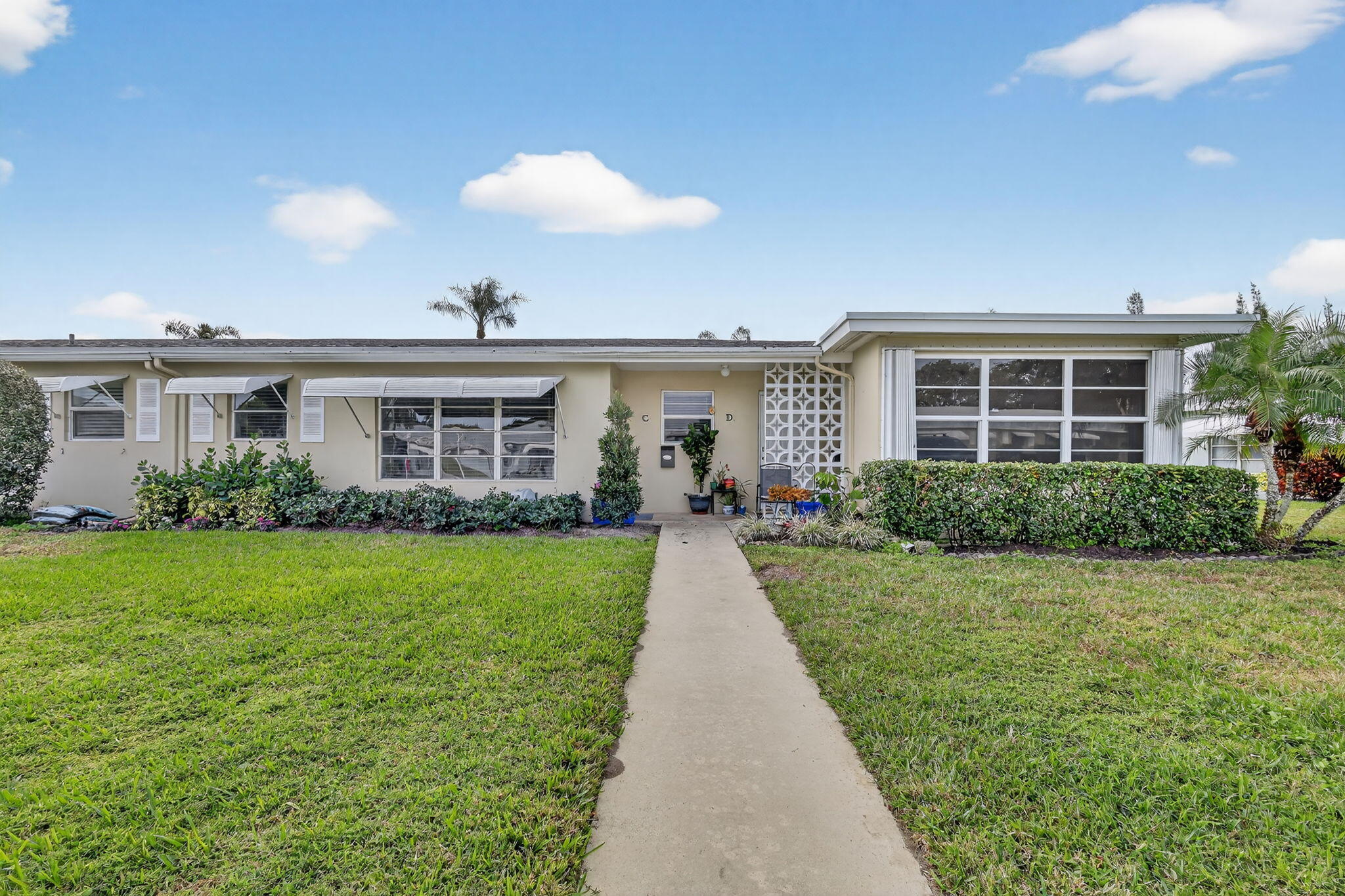 212 West High Point Terrace, Unit C Delray Beach, FL 33445 - Photo 2 of 35 a front view of a house with a yard