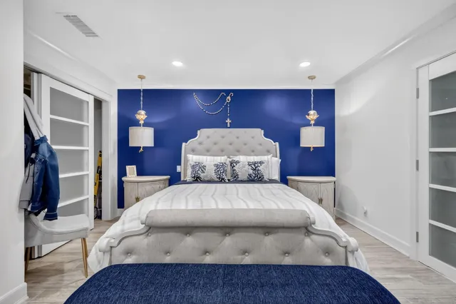 a bed sitting in a room next to a lamp