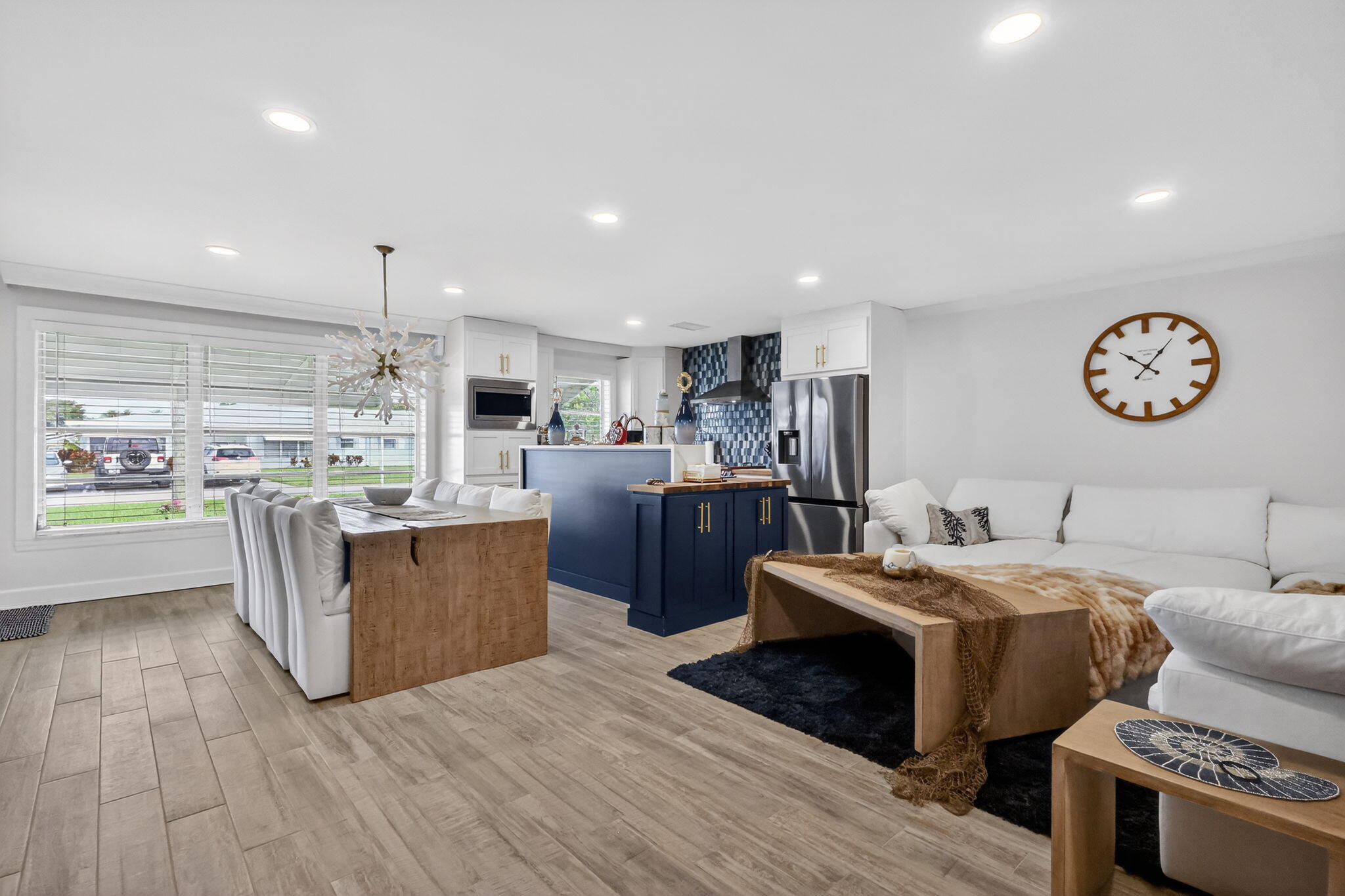 212 West High Point Terrace, Unit C Delray Beach, FL 33445 - Photo 10 of 35 a large kitchen with stainless steel appliances kitchen island granite countertop a stove a refrigerator a oven and a dining table with wooden floor