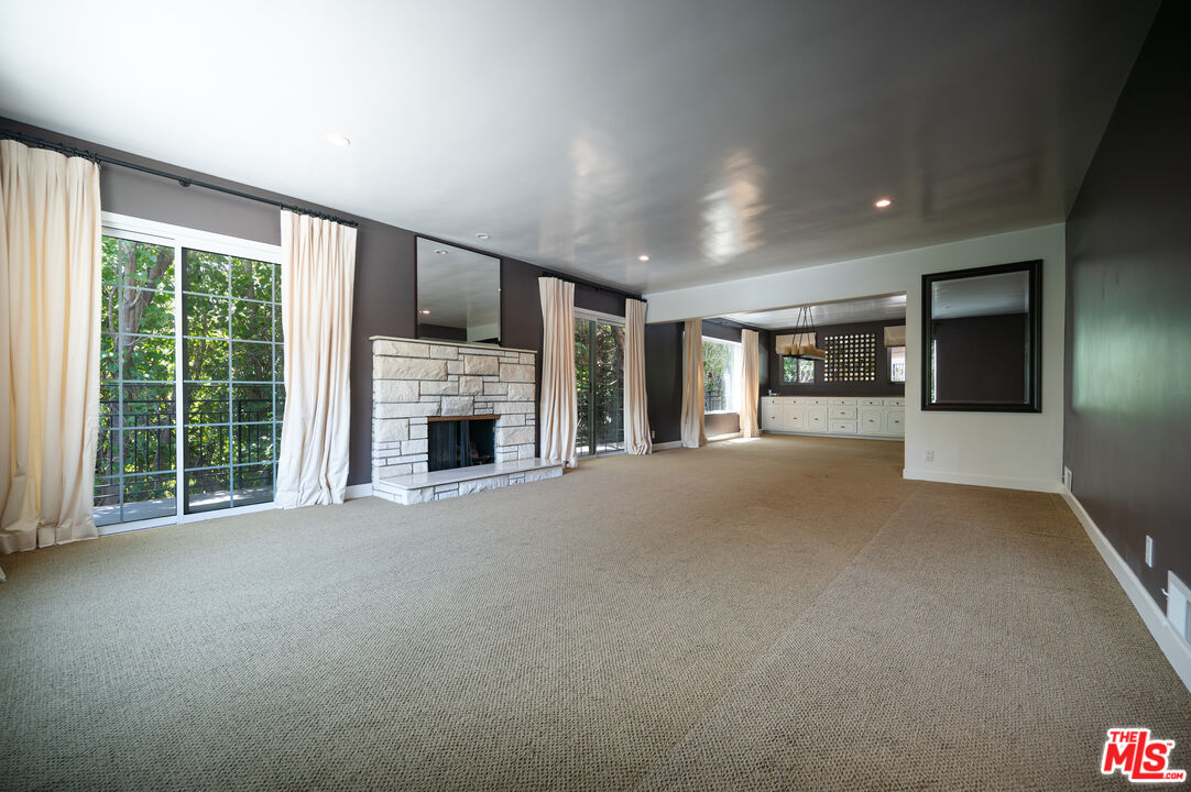 503 North Greencraig Road Los Angeles, CA 90049 - Photo 8 of 59 a view of an empty room with a fireplace and a window