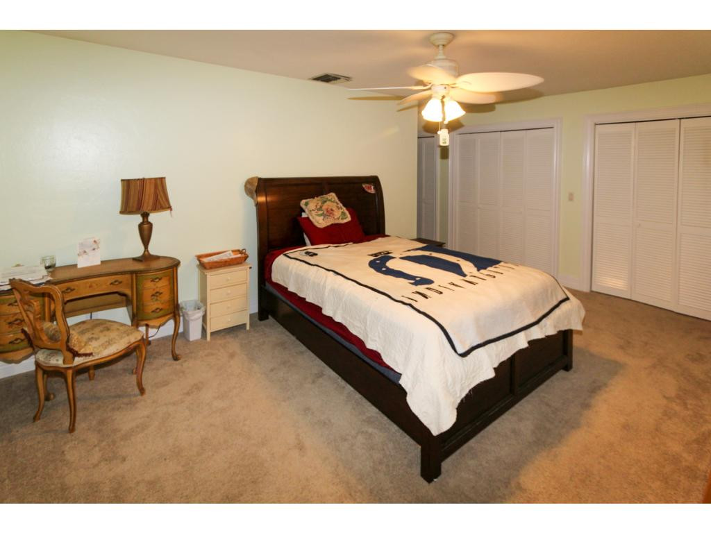 4125 13th Avenue Southwest Naples, FL 34116 - Photo 11 of 34 a bedroom with a bed and a chandelier