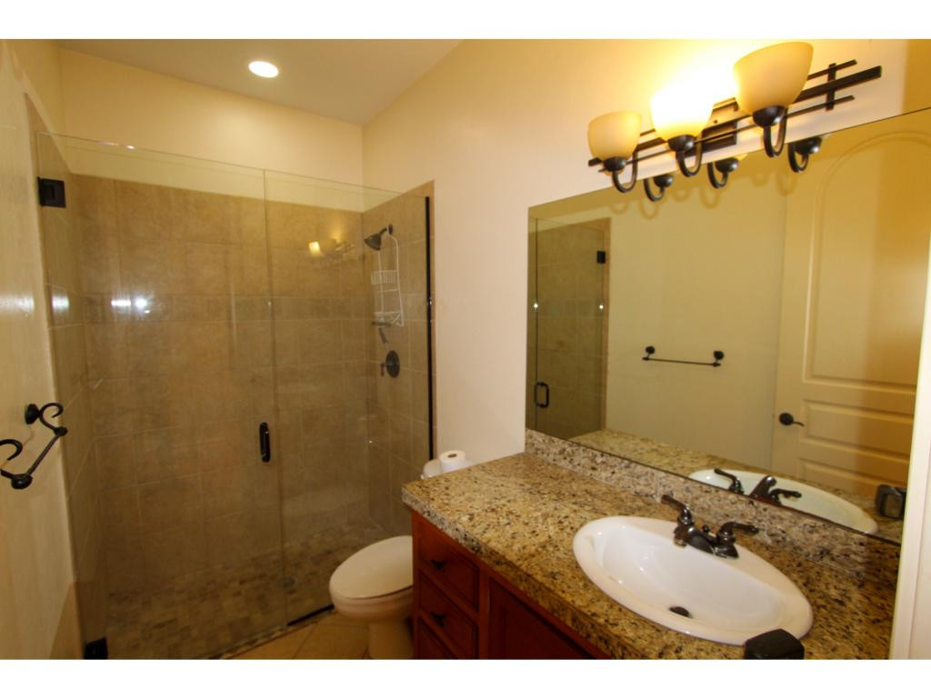 4125 13th Avenue Southwest Naples, FL 34116 - Photo 25 of 34 a bathroom with a granite countertop sink a mirror and shower