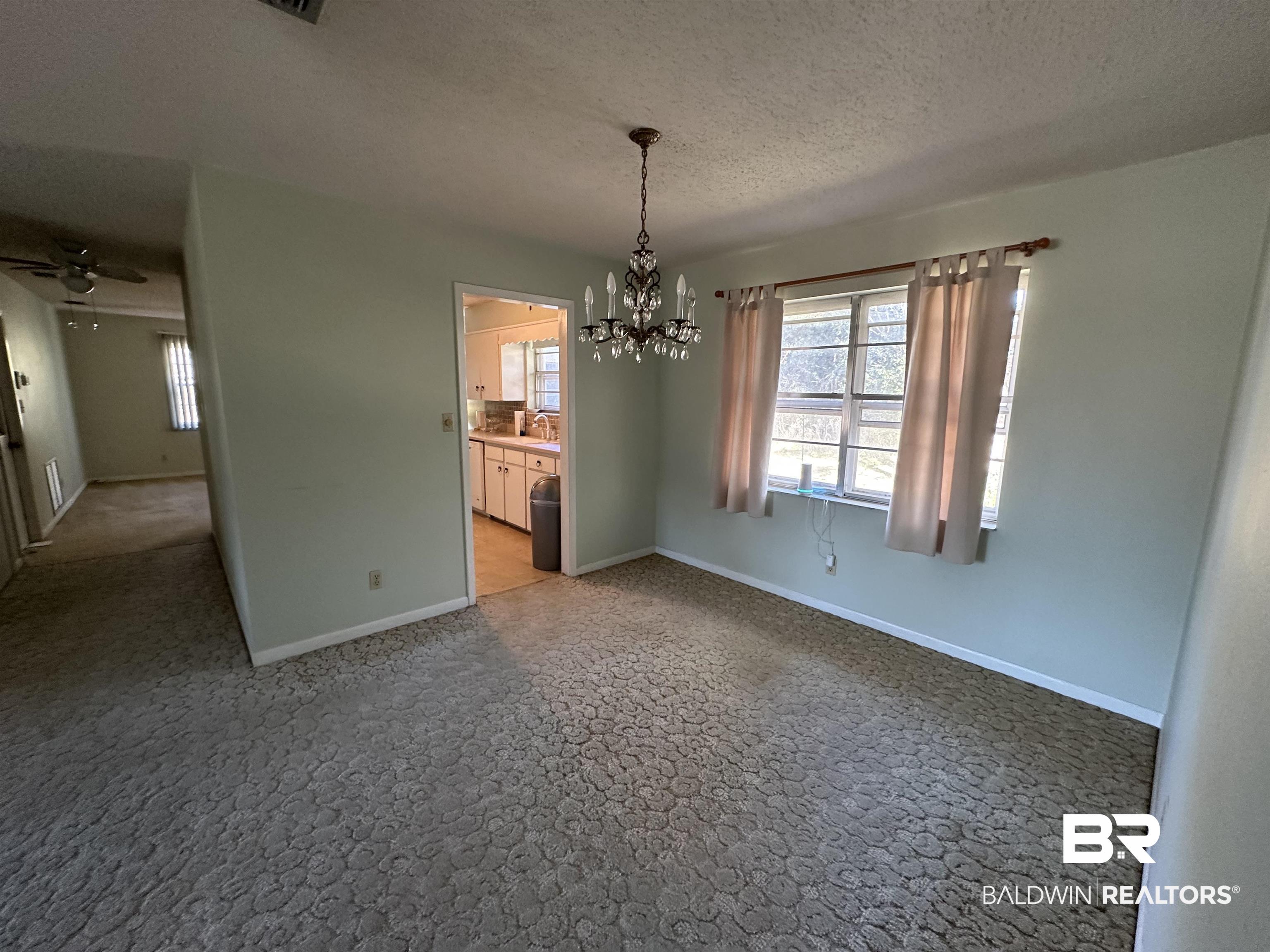 1 Yupon Circle Foley, AL 36535 - Photo 12 of 30 Unfurnished dining area with a chandelier, a textured ceiling, and ceiling fan