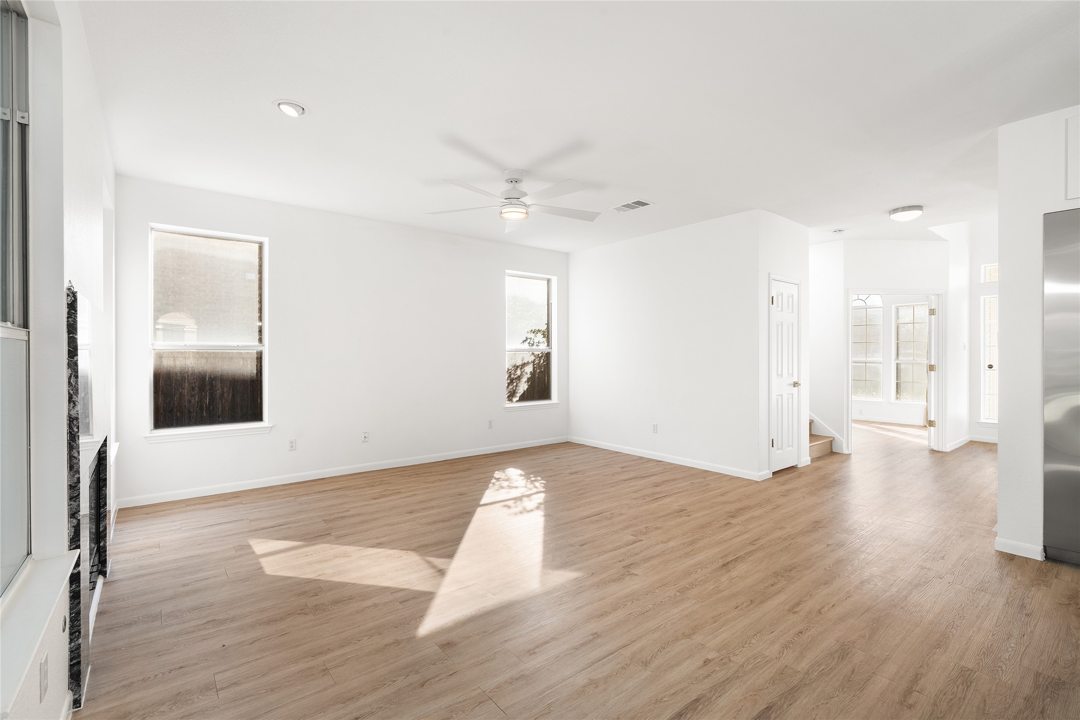206 River Down Road Georgetown, TX 78628 - Photo 14 of 39 Expansive living area featuring light wood-finish flooring, crisp white walls, multiple windows, recessed lighting, and a ceiling fan