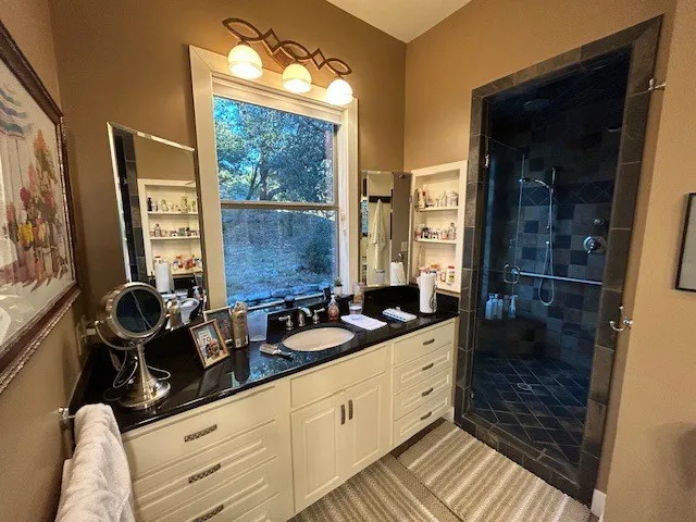 a bathroom with a granite countertop sink and a mirror