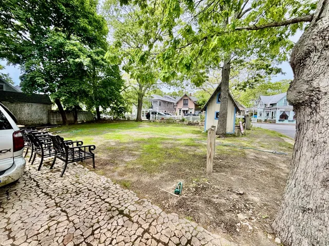 a view of a patio with table and chairs with wooden floor and fence