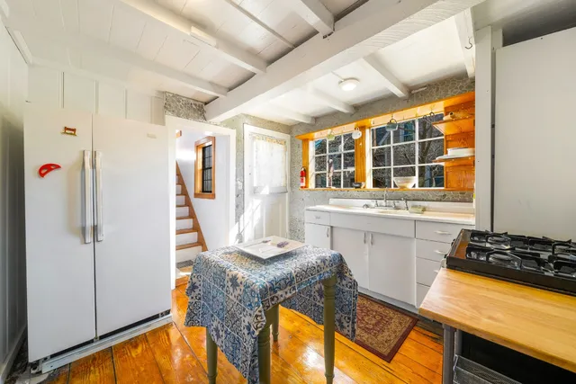 a view of a kitchen with a sink and dishwasher a refrigerator with wooden floor