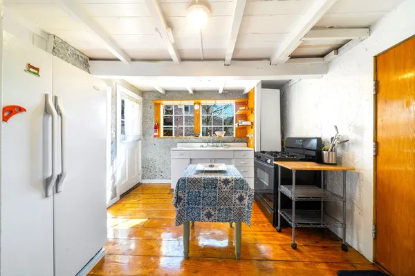a room with stainless steel appliances kitchen island granite countertop furniture and a large window