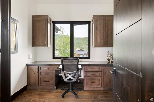 11547 Soaring Hawk Lane Hideout, UT 84036 - Photo 19 of 43 Dedicated workspace featuring custom wood cabinetry, integrated desk, and coordinating wood-finish flooring