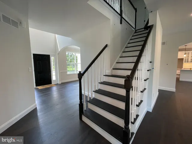 a view of staircase with wooden floor and white walls