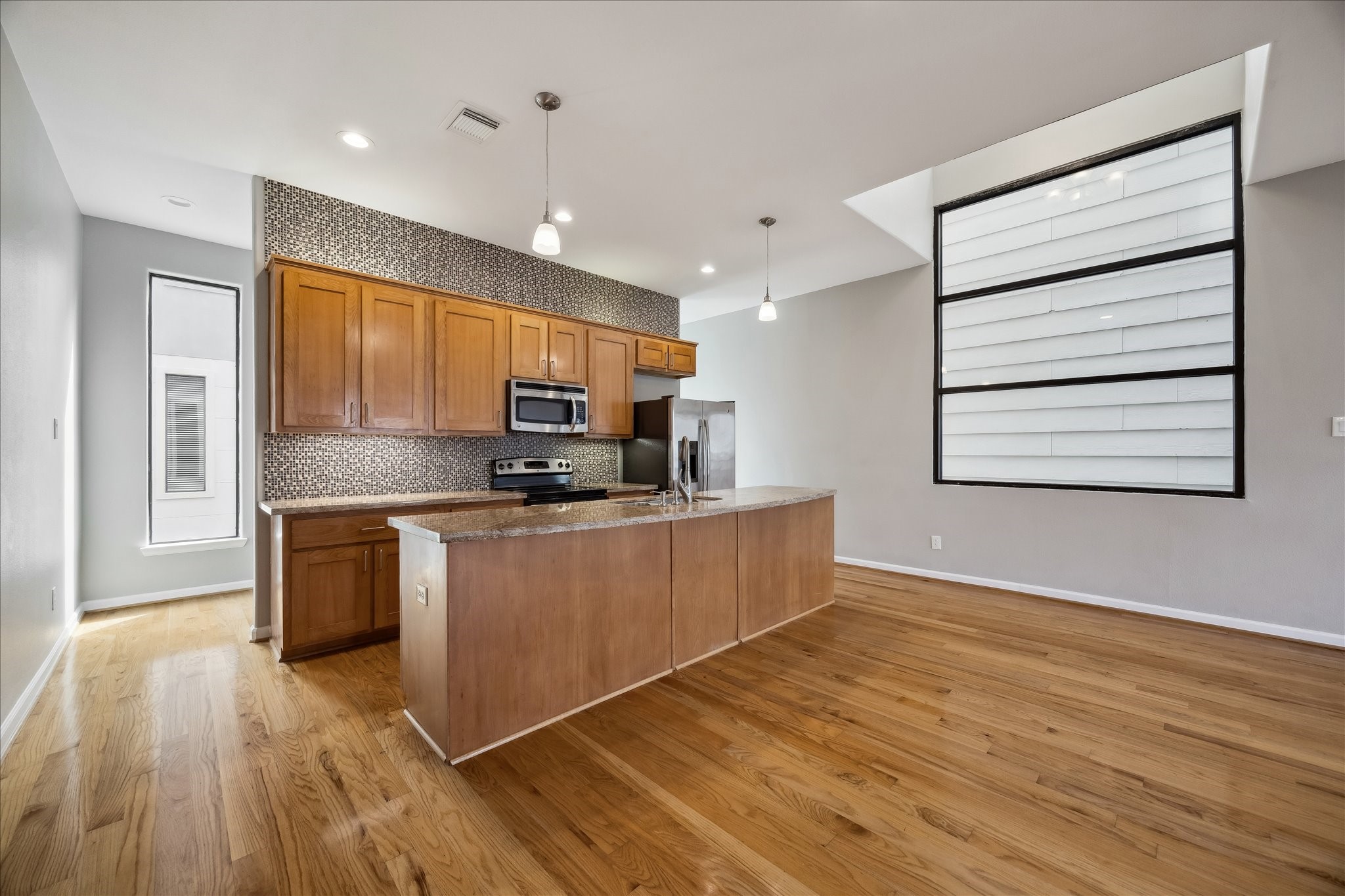 802 Waverly Street, Unit D Houston, TX 77007 - Photo 4 of 30 a kitchen with stainless steel appliances granite countertop a stove a sink and a refrigerator