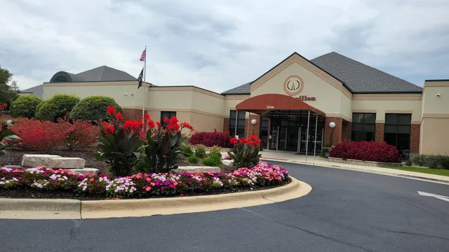 a front view of a house with a yard and potted plants