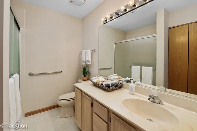 a bathroom with a granite countertop sink mirror vanity and toilet