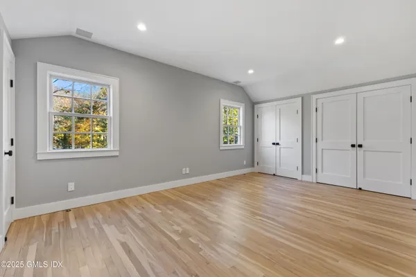 an empty room with window and wooden floor