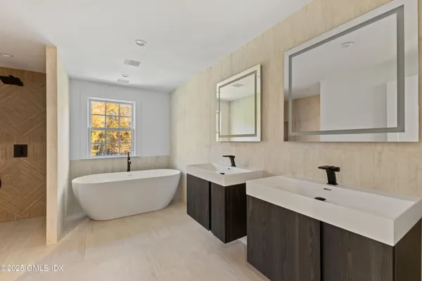 a bathroom with a double vanity sink mirror and bathtub