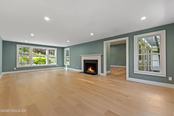 a view of an empty room with a window and fireplace