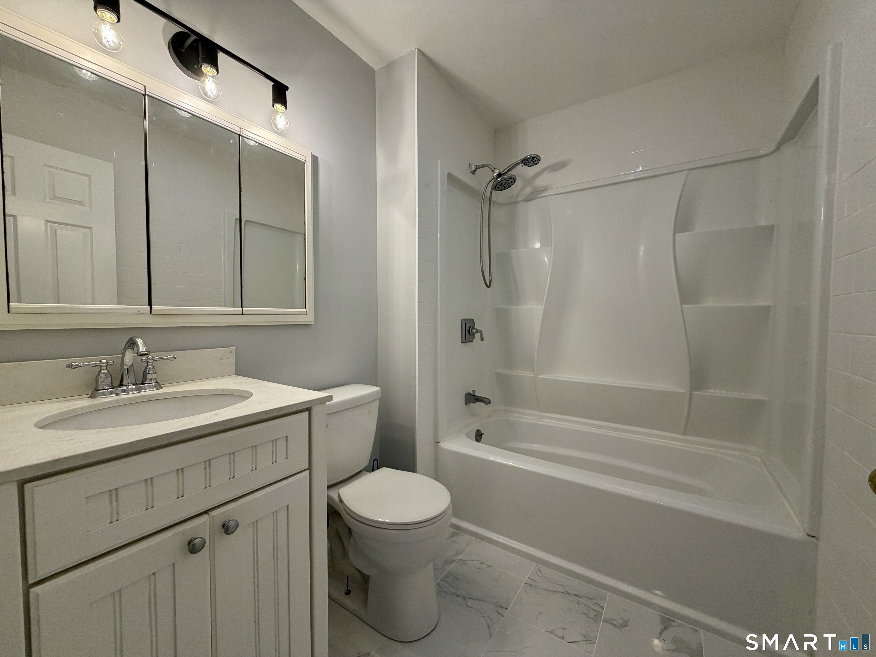 154 East Main Street, Unit A Branford, CT 06405 - Photo 9 of 17 a bathroom with a sink toilet vanity and shower