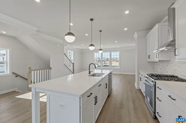a view of a big room with wooden floor and windows