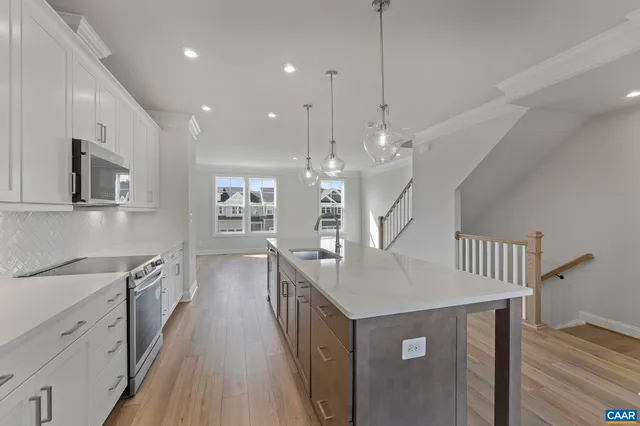 a kitchen with kitchen island a sink stove and wooden floor