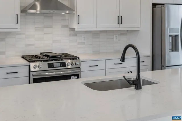 a view of a refrigerator in kitchen and white cabinets