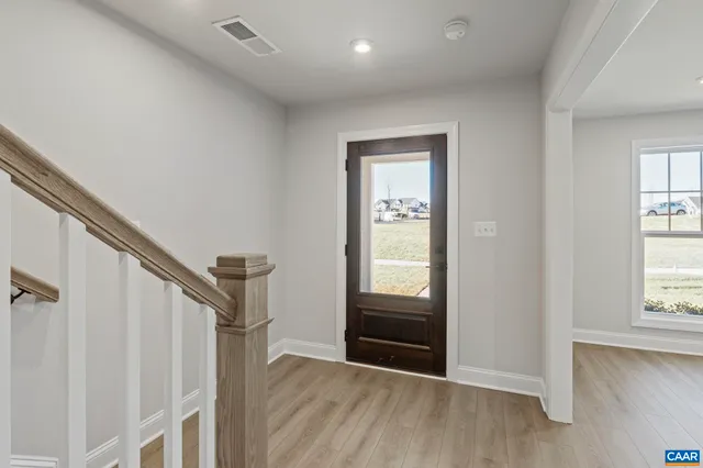 a large kitchen with stainless steel appliances granite countertop a refrigerator a sink dishwasher a stove and white cabinets with wooden floor