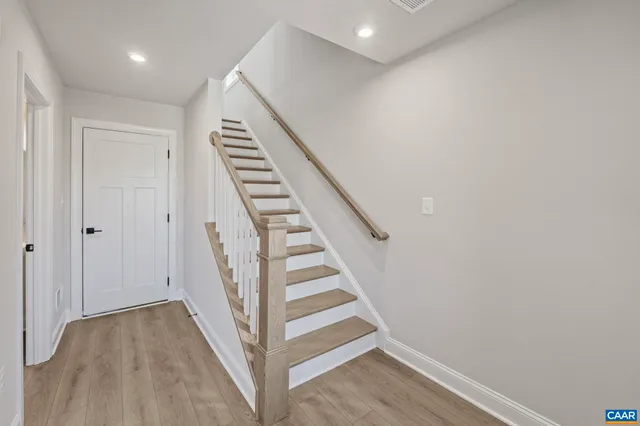 a large kitchen with kitchen island a stove a sink a center island and wooden floor