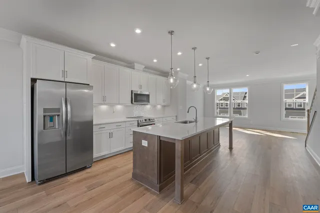 a kitchen with stainless steel appliances a sink cabinets and wooden floor
