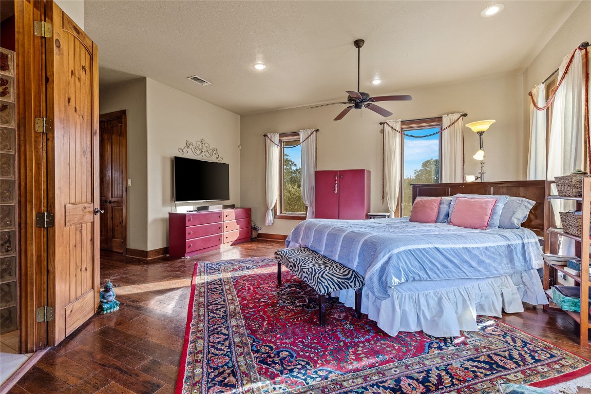 5059 Trainer Wuest Road Blanco, TX 78606 - Photo 15 of 39 a spacious bedroom with a bed and a flat screen tv
