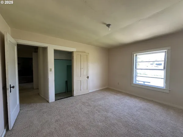 an empty room with windows and closet