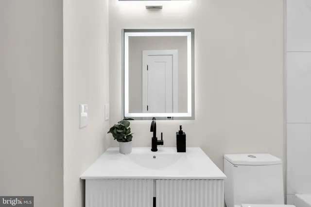 a bathroom with a sink a toilet and mirror