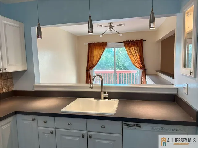 a kitchen with a sink a window and cabinets