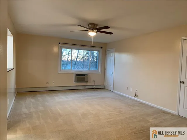 an empty room with windows and ceiling fan