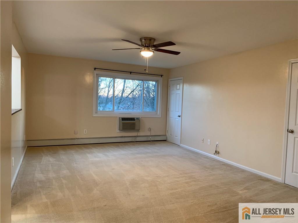 2 Lake Avenue, Unit 7B East Brunswick, NJ 08816 - Photo 8 of 10 an empty room with windows and ceiling fan
