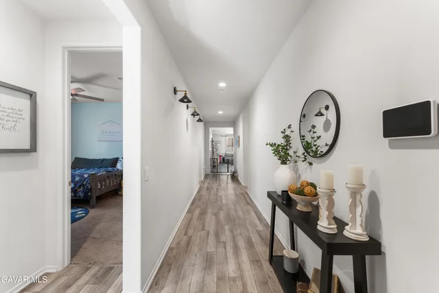 a view of a hallway to a livingroom and a dining room with furniture