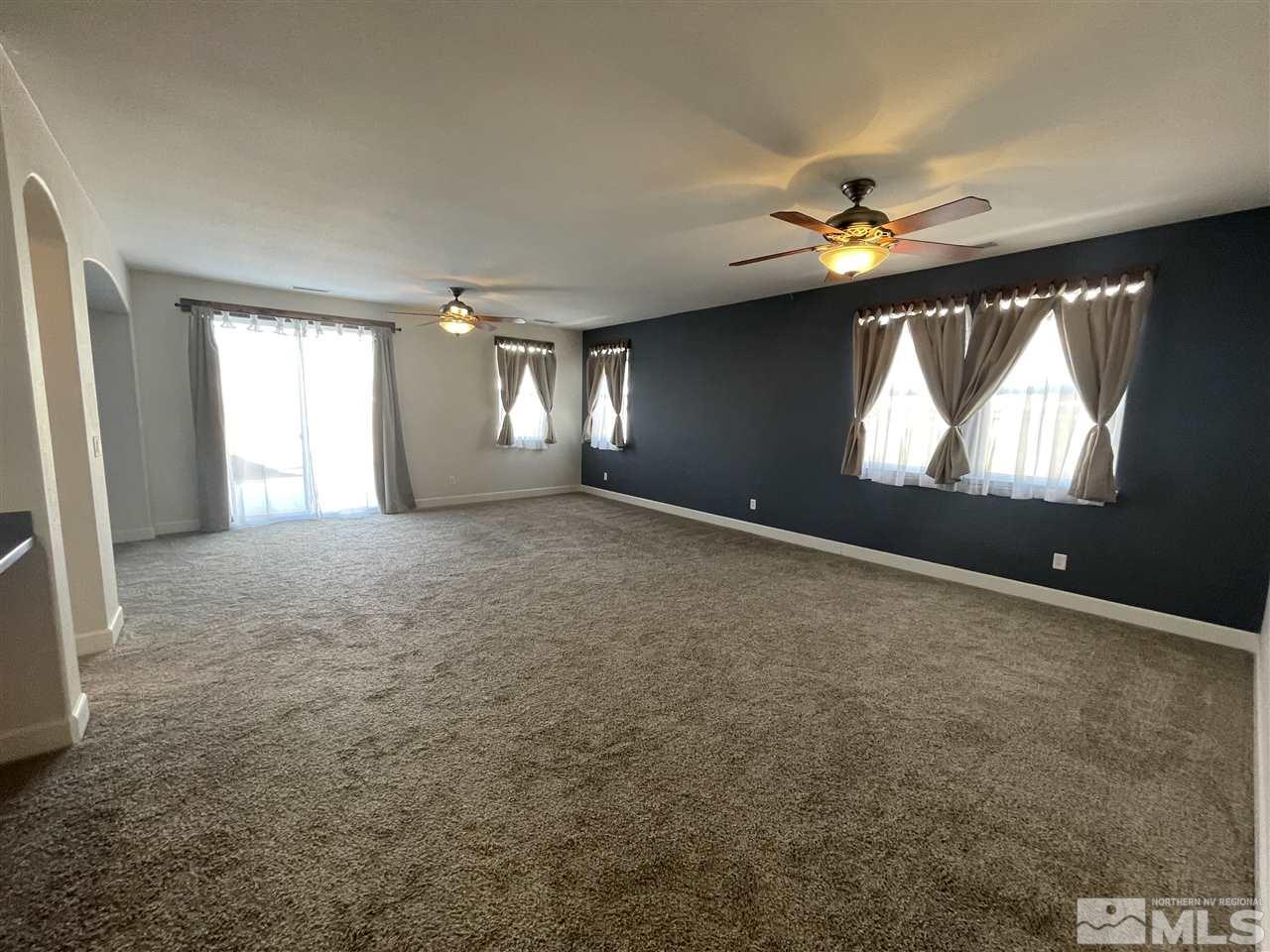 455 Terracina Way Reno, NV 89521 - Photo 4 of 36 an empty room with windows and chandelier fan
