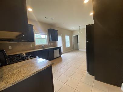 3829 Baxley Ridge Drive Suwanee, GA 30024 - Photo 4 of 11 a kitchen with granite countertop a sink and a stove top oven