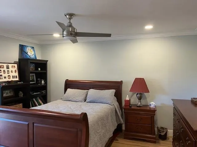a bedroom with a bed and a flat tv screen on dresser