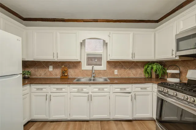 a kitchen with granite countertop white cabinets and white appliances