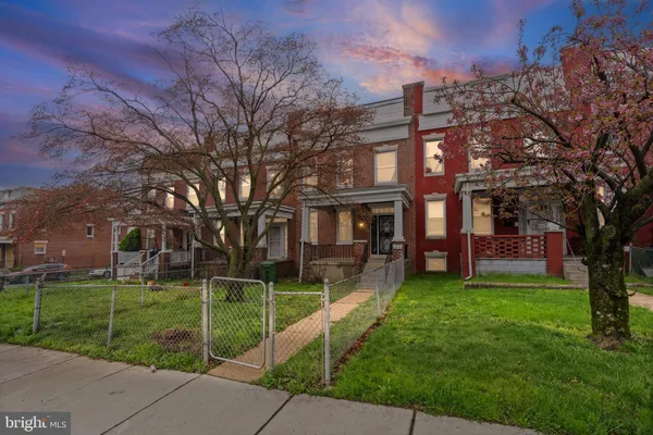 a view of a house with a yard and large trees