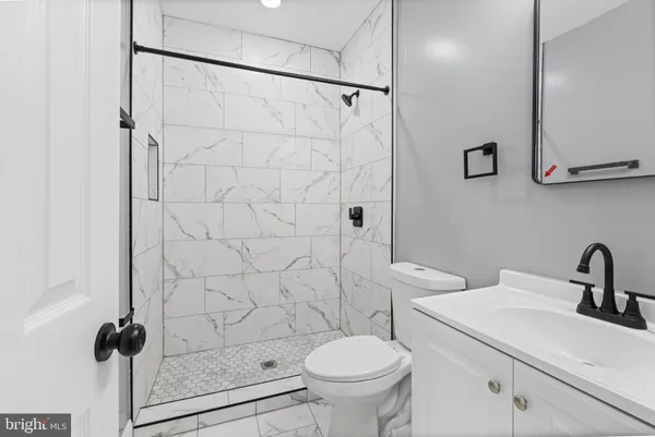 a bathroom with a sink a toilet and shower