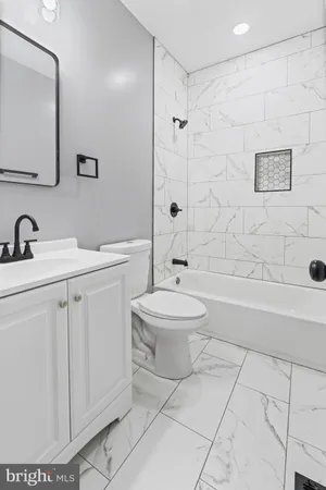 a bathroom with a shower sink vanity and toilet