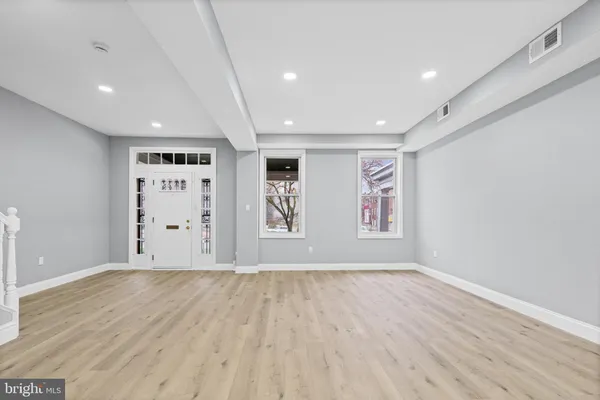 a view of an empty room with wooden floor