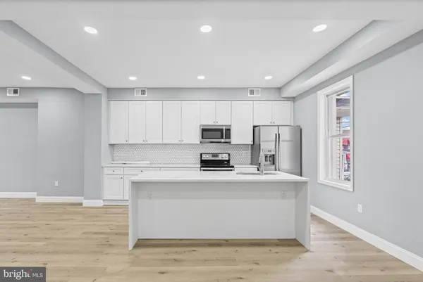 a kitchen with kitchen island a sink stainless steel appliances and cabinets