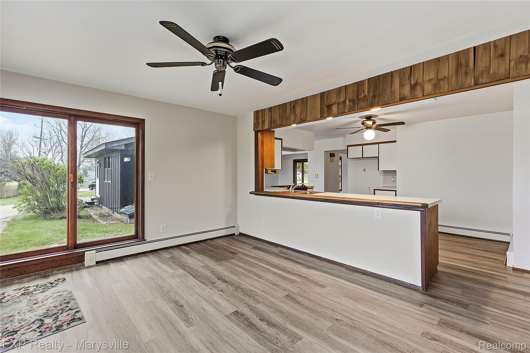3345 Beach Road Port Huron, MI 48060 - Photo 3 of 89 Unfurnished living room featuring a baseboard radiator, ceiling fan, and dark wood-style flooring