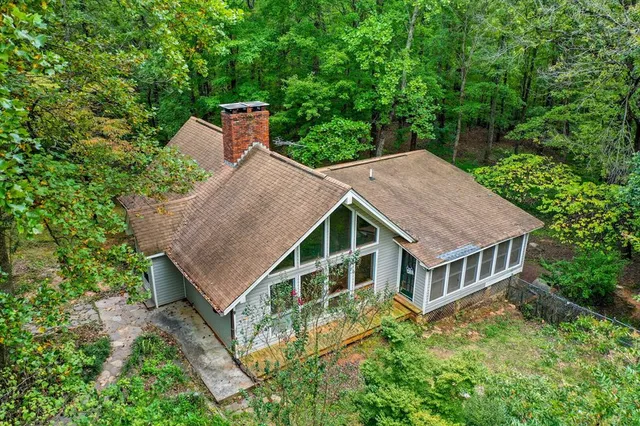 aerial view of a house with a yard and large trees