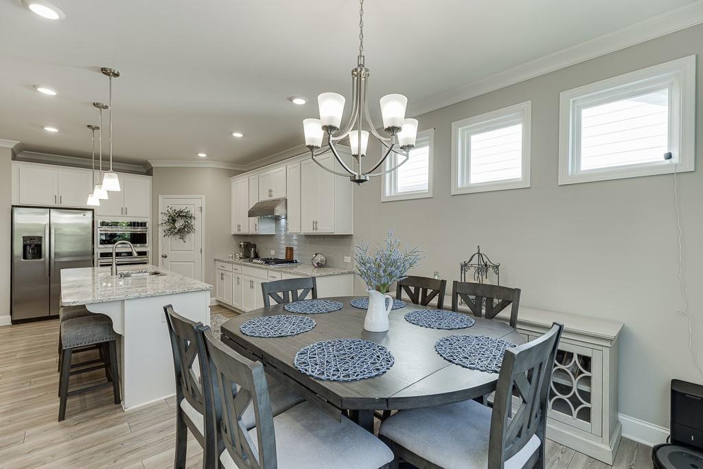 5188 Watchmans Cove Gainesville, GA 30504 - Photo 20 of 90 a kitchen with stainless steel appliances granite countertop a dining table and chairs